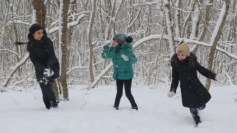 Mother and two daughters playing snowballs Stock Footage 72372684