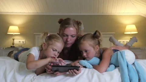 Mother and two daughters spend an exciting evening together. Concept: motherhood Stock Footage 146043355