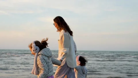 Mother and Two Daughters on Windy Beach at Sunset Stock Footage 319833598