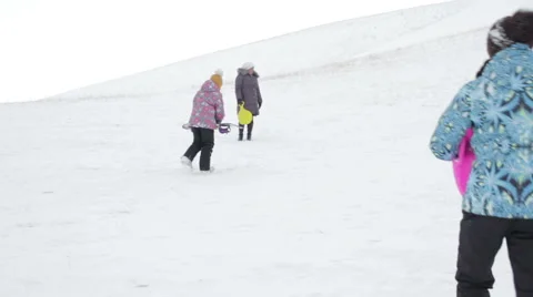 Mother and two girls resting on the slope of the mountain in winter Stock Footage 59779985
