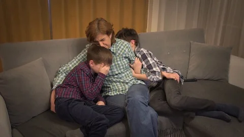 Mother and two scared sons watching horror movie on TV Stock Footage 125011756