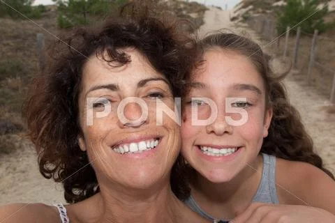 Mother and young girl hugging and having fun outdoor beach Stock Photos
