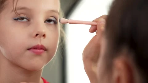 Mother applying makeup to her cute little daughter, close-up Stock Footage 268830872