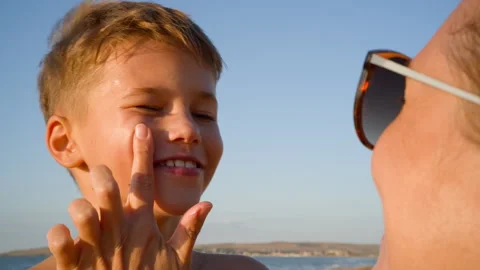 Mother Applying Sunblock to Son's Face Close-up Stock Footage 318157089