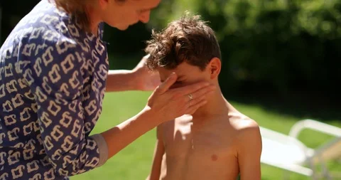 Mother applying sunscreen to child son outdoors. Parent applies sunblock to k Stock Footage 125867166