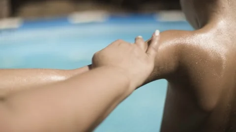 Mother applying sunscreen cream on child arm by swimming pool skin protection Stock Footage 342378065