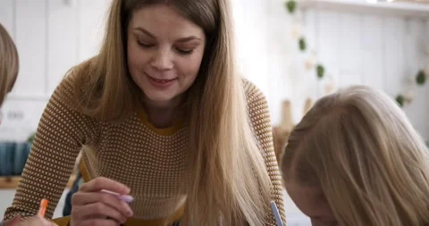 Mother assisting daughters in solving mathematics problems Stock Footage 238996292