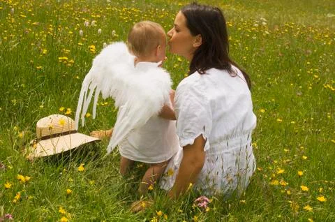 Mother with baby (2-3) in the meadow, angel's wings, rear view Stock Photos