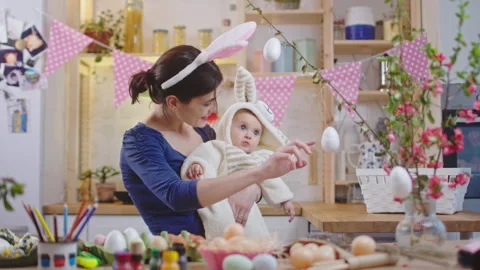Mother with baby decorating easter eggs. Stock Footage 175881186