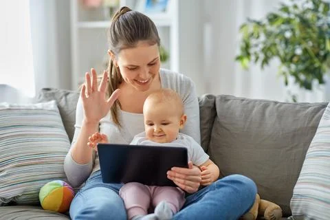 Mother with baby having video call on tablet pc Stock Photos