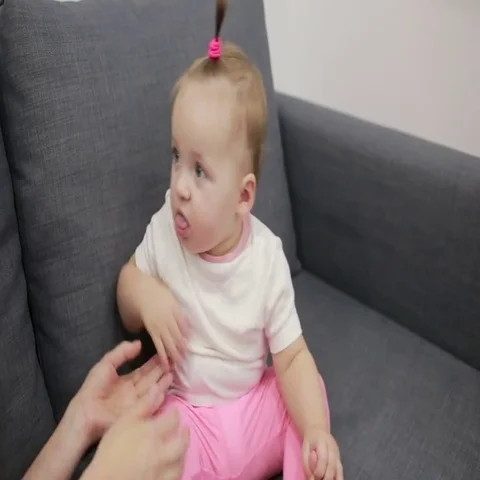 Mother with baby playing on couch Stock Footage