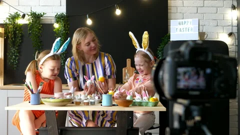 Mother blogger is decorating Easter eggs with her daughters at home indoors Video stock 151050165