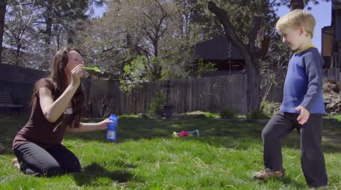 Mother blows bubbles for son Stock Footage 66527947
