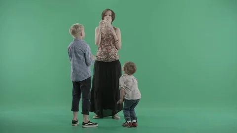 Mother blows soap bubbles for her two little sons Stock Footage 77634743