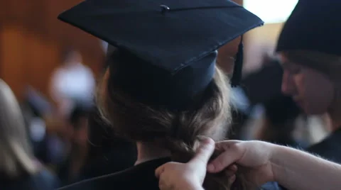 Mother braiding daughter's hair. Preparations for graduation ceremony at college Stock Footage