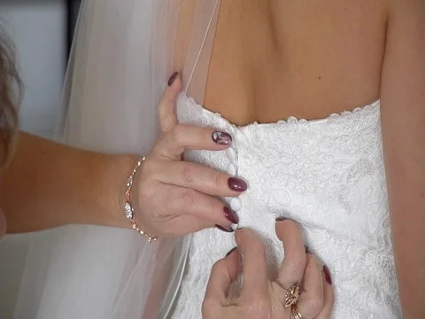 Mother buttoning the bride's wedding dress Stock Footage 78809159