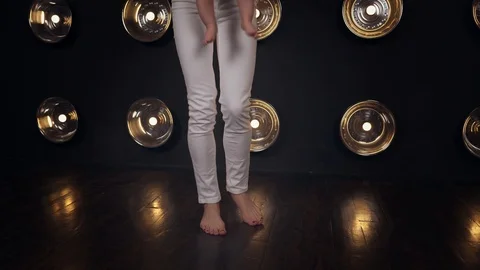 Mother is carefully helping her lttle toddler in white bodysuit to make his Stock Footage 86532068