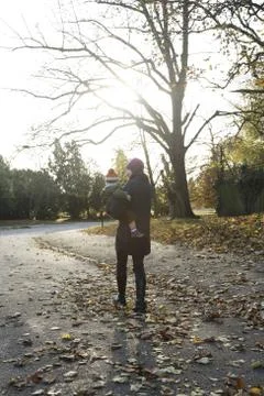 Mother carrying son while strolling in the park Stock Photos