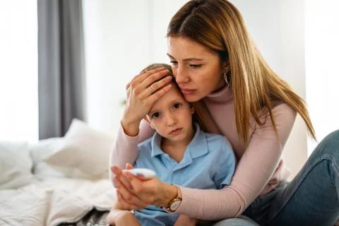 Mother checking temperature of her sick child Stock Photos