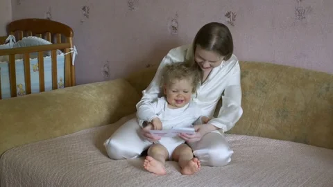 Mother with a child have fun considering pictures with animals. Stock Footage 130651441