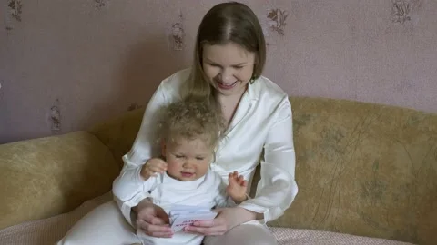 Mother with a child have fun considering pictures with animals. Stock Footage 130651641