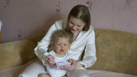 Mother with a child have fun considering pictures with animals. Stock Footage 131560864