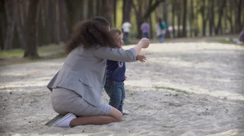 Mother with child playing with sand Stock Footage 62016749