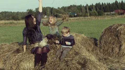 Mother with children playing on a haystack. Stock Footage 84186211