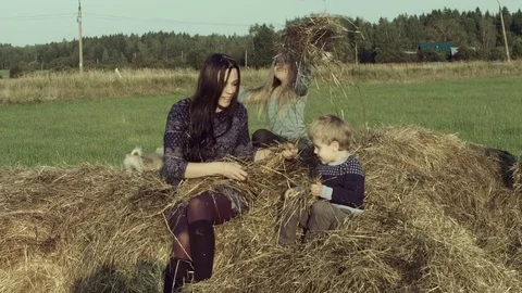Mother with children playing on a haystack. Stock Footage 84186257