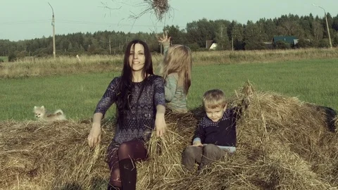 Mother with children playing on a haystack. Stock Footage 84186300