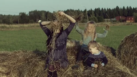 Mother with children playing on a haystack. Stock Footage 84186331