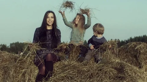 Mother with children playing on a haystack. Stock Footage 84186372