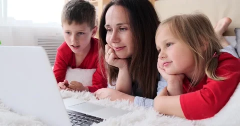 Mother with children using laptop lying on bed Stock Footage 156519867