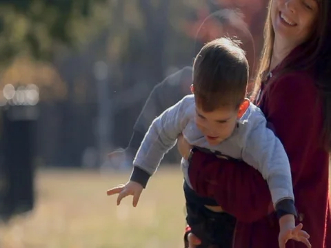 Mother circling son, playing in fall park. Happy Family picnic Stock Footage 74006061