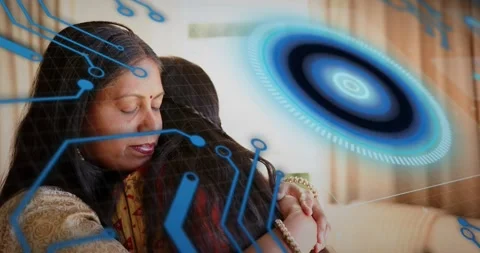 Mother comforting daughter on sofa, frames sparking blue tech holo ring and Stock Footage 321301177