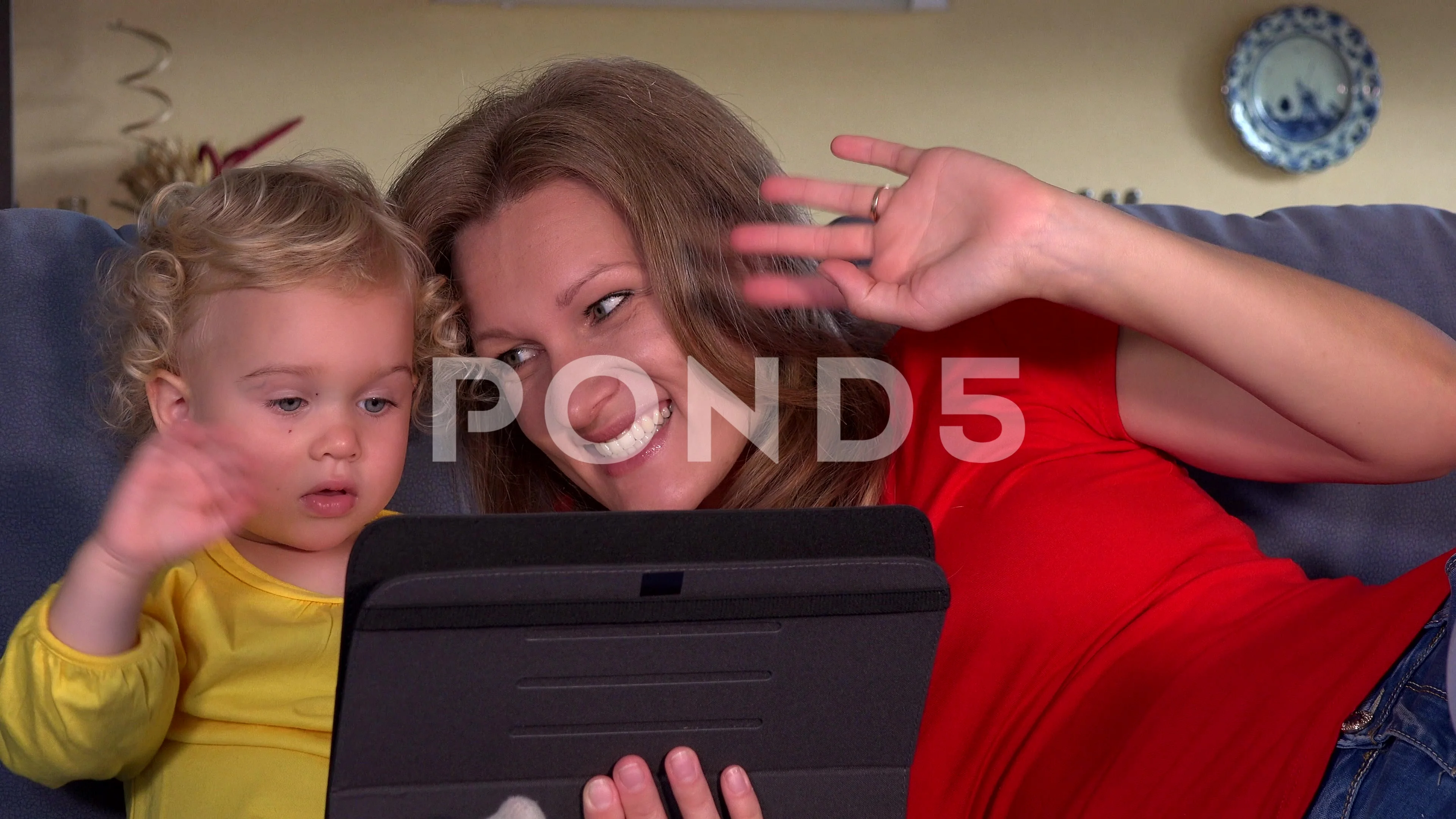 mother with daughter blow kiss to father on tablet video conversation