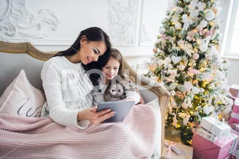 Mother With Daughter On Couch Using Tablet Computer Happy Smiling Young Family Stock Photos
