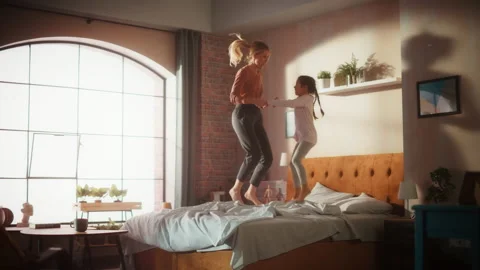 Mother Daughter Jumping on Bed Stock Footage 219394537