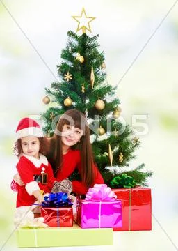 Mother with daughter near the Christmas tree Stock Photos