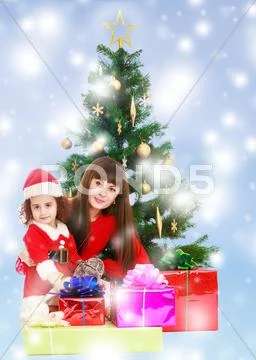 Mother with daughter near the Christmas tree Stock Photos