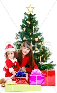 Mother with daughter near the Christmas tree Stock Photos