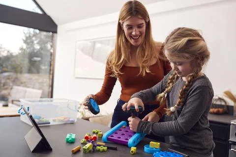 Mother With Daughter Playing With Engineering Construction Kit Together At Home Stock Photos
