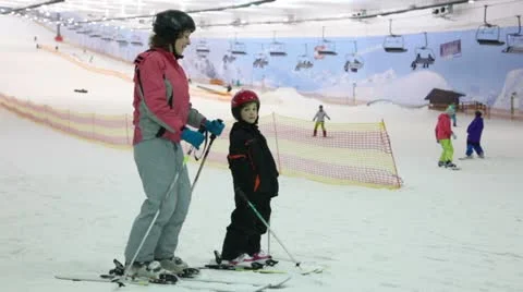Mother with daughter stand on ski and talk Stock Footage