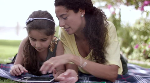 Mother with daughter using digital tablet at park. Stock Footage 63511538