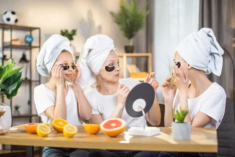 Mother with daughters using hydrogel eye patches at home Stock Photos