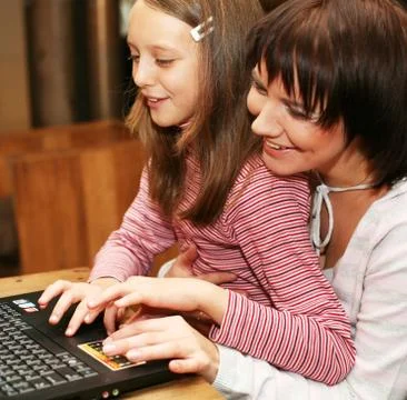 Mother &amp; daugther looking at computer Stock-Fotos