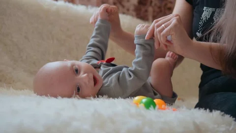 A mother does developmental physical exercises for her newborn baby. Mother care Video stock 132999508