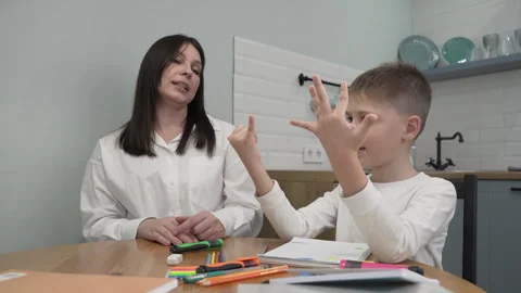 Mother does mathematics with her son while sitting at the kitchen table Video stock 259322803