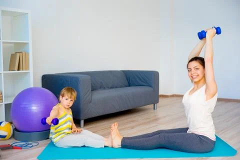 Mother is doing exercises Stock Photos