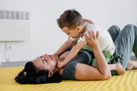 Mother doing physical exercises, playing with disabled boy Stock Photos
